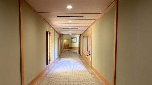 a hallway with a long corridor with a long hallway at Hotel Morinokaze Oshuku in Shizukuishi