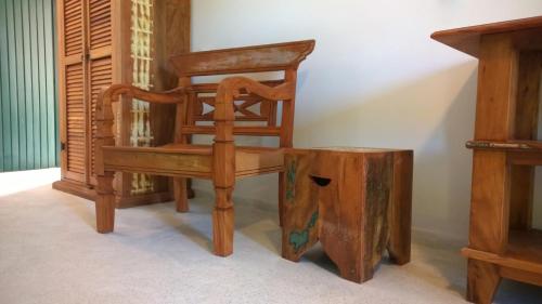 a wooden chair sitting next to a wooden stump at Angá Beach Hotel in São Miguel dos Milagres