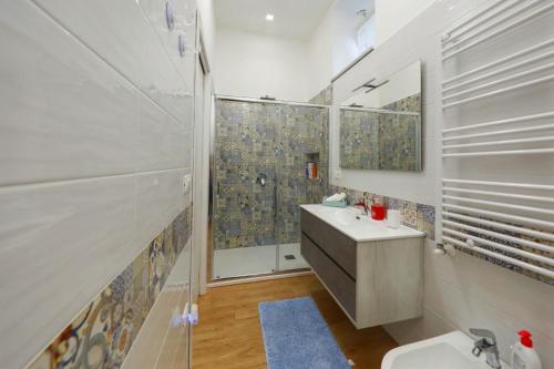 a white bathroom with a sink and a shower at Vient' e mar suite in Castellammare di Stabia