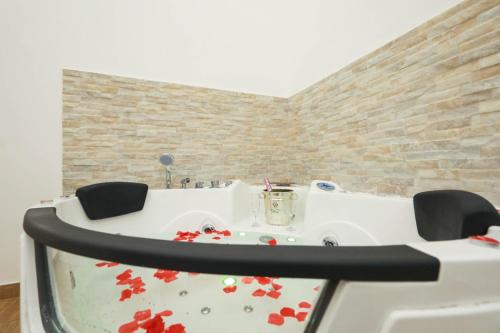 a white bath tub with red flowers on it at Vient' e mar suite in Castellammare di Stabia