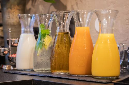 four glass vases filled with different types of orange juice at Stacklerhof in Neustift im Stubaital