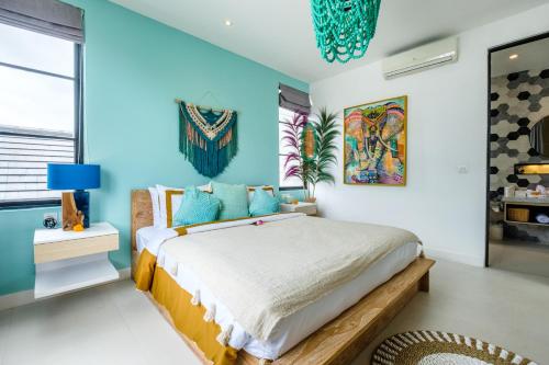 a bedroom with a large bed with blue walls at Maison Jolie Villa by Hombali in Canggu