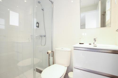 a white bathroom with a toilet and a shower at Apt RIERES in Port de Pollensa