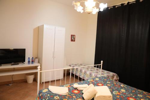 1 dormitorio con 1 cama, escritorio y TV en La dimora di Nonno Nuccio, en Ragusa