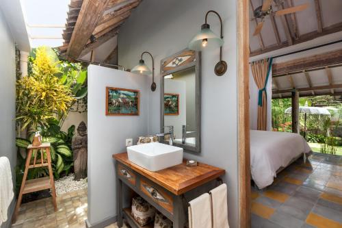 La salle de bains est pourvue d'un lavabo et d'un lit dans la chambre. dans l'établissement Villa Koyama, à Seminyak