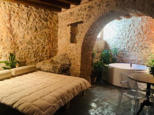 uma casa de banho com uma cama grande e uma banheira em WUNDERGARTEN Rural Spa House em Gratteri