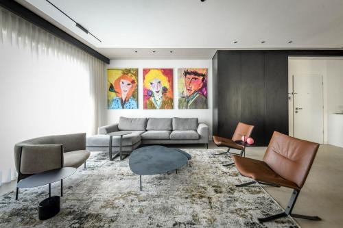 uma sala de estar com um sofá e cadeiras em Modern and Vibrant 2BR apartment with Private Balcony by Sea N' Rent em Tel Aviv