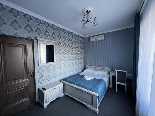 a small bedroom with a bed and a table at Zolotoy Fazan in Mykolaiv