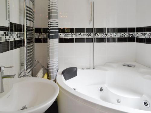 uma casa de banho branca com uma banheira e um lavatório em The Pigsty em Llantrisant