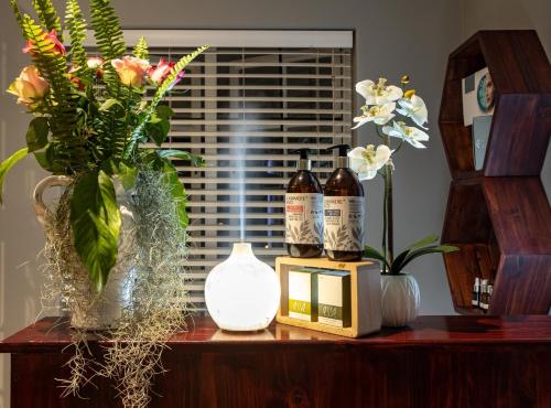a table with bottles of wine and flowers on it at Shandon Lodge Guest House & Spa in Nelspruit