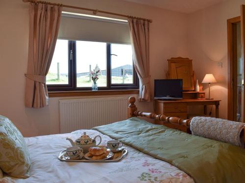 a bedroom with a bed with a tray of tea sets on it at Lawford Lodge in Bonnybridge