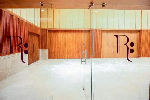 a bathroom with a shower with the rbc logo on the wall at Gulab Kothi by Royal Orchid Hotels Limited Varanasi in Varanasi