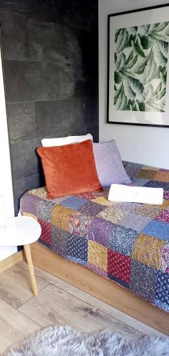 a bed with two pillows on it in a room at Jaśmin Apartamenty in Krynica Zdrój