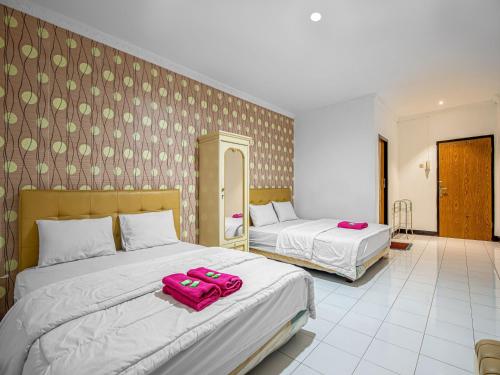 - 2 lits dans une chambre d'hôtel avec des serviettes roses dans l'établissement Hotel Cempaka Sari, à Jakarta