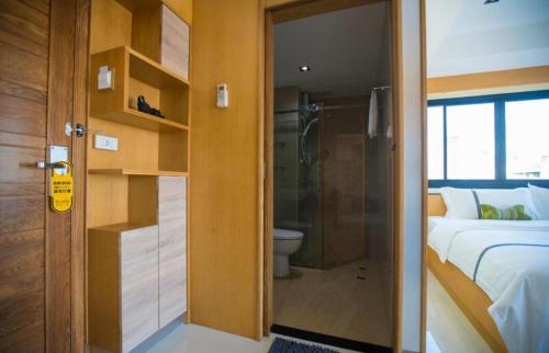 une porte menant à une chambre avec un lit et une salle de bains. dans l'établissement L18 residence แอลสิบแปด เรสซิเดนซ์, à Ban Zong Katiam