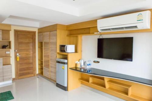 une petite cuisine avec une télévision et un comptoir dans l'établissement L18 residence แอลสิบแปด เรสซิเดนซ์, à Ban Zong Katiam