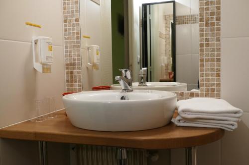 y baño con lavabo blanco y espejo. en Hotel Epi d'Or, en Angulema