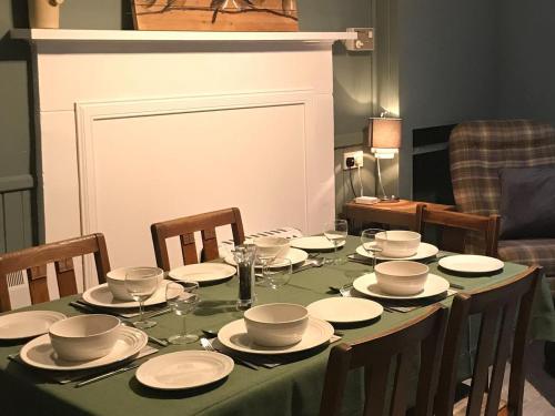 mesa de comedor con mantel verde y platos blancos en Ardville, en Talmine