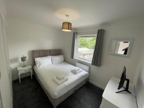 a small bedroom with a bed and a window at Casa Fresa - Kintail House in Broughty Ferry