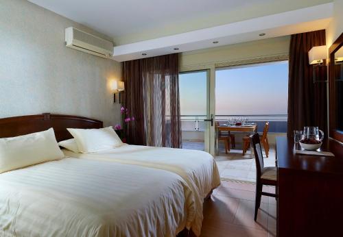 a hotel room with a bed and a view of the ocean at Macaris Suites & Spa in Rethymno