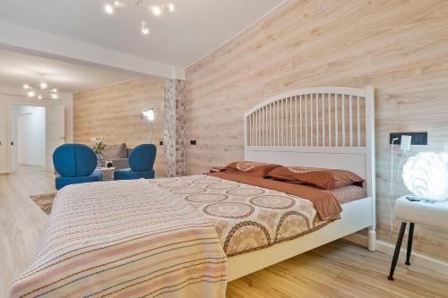 a bedroom with a large bed and two blue chairs at Apartament Mercado Central in Alicante