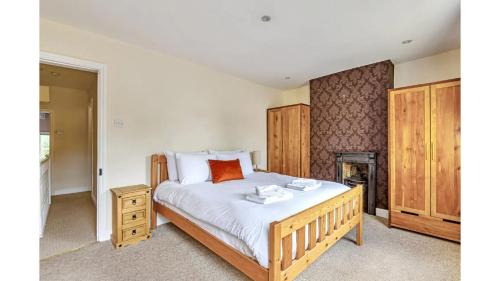 a bedroom with a bed with white sheets and wooden cabinets at Charming Victorian Townhouse Central Oxford in Oxford