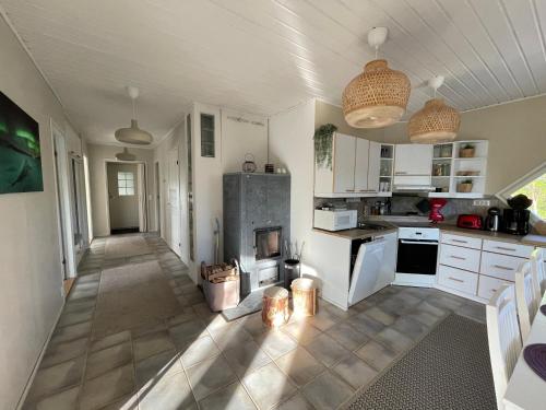 Nuorgam的住宿－Villa Arktika porealtaallinen mökki Nuorgamissa Tenojoen ja tunturien vieressä，厨房配有白色橱柜和炉灶。