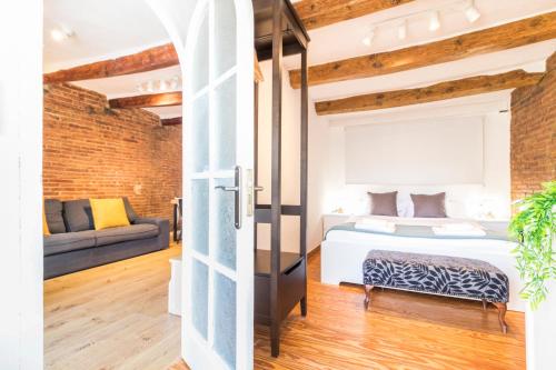 a bedroom and a living room with a bed and a couch at Precioso Apartamento en Mercat Sant Antoni in Barcelona