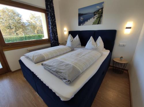 two beds in a room with a large window at Pension zum Mühlrad in Millstatt