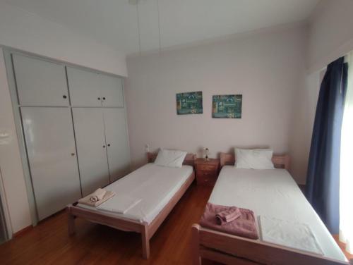 two beds in a room with white cabinets at Apartment 110 sqm free parking in Patra