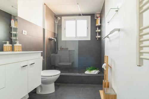 a bathroom with a toilet and a shower with a window at Precioso Apartamento en Mercat Sant Antoni in Barcelona