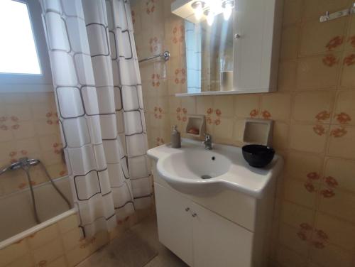 a bathroom with a sink and a shower and a mirror at Apartment 110 sqm free parking in Patra