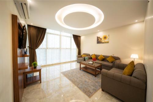 a living room with a couch and a large window at القصر للاجنحة الفندقية الإسكان in Khamis Mushayt
