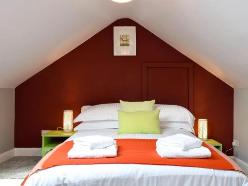 a bedroom with a large bed with orange and white at Heather Lea in Summer Bridge