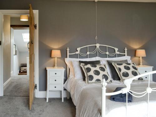 een slaapkamer met een wit bed met 2 nachtkastjes en 2 lampen bij Grace Cottage in Umberleigh Bridge