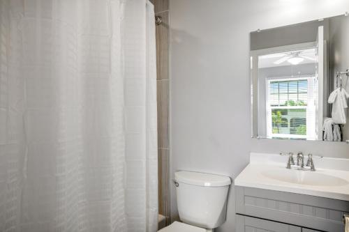 a white bathroom with a toilet and a sink at Key Lime Villa in Duck Key