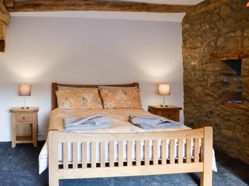 a bedroom with a wooden bed with two night stands at Pistyll Gwyn in Llanwrthwl