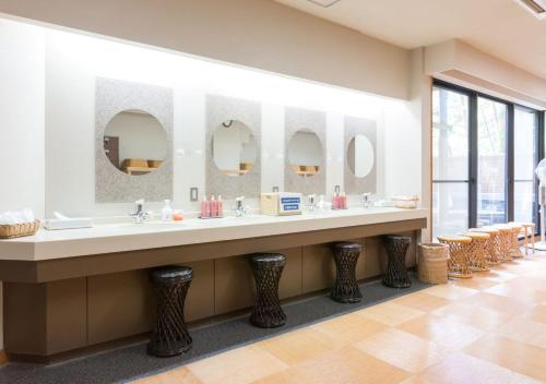 ein Badezimmer mit zwei Waschbecken und drei Spiegeln in der Unterkunft Yatsugatake Hotel Fuuka in Hokuto