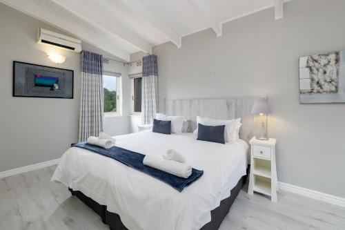 um quarto com uma grande cama branca e uma janela em San Lameer Villa 3108 - 4 Bedroom Classic - 8 pax - San Lameer Rental Agency em Southbroom