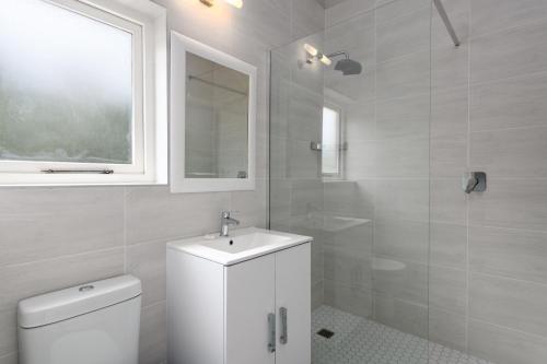 uma casa de banho branca com um lavatório e um WC em San Lameer Villa 3108 - 4 Bedroom Classic - 8 pax - San Lameer Rental Agency em Southbroom