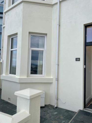 a white building with two windows on the side of it at Luxury house with Sea views in Bangor