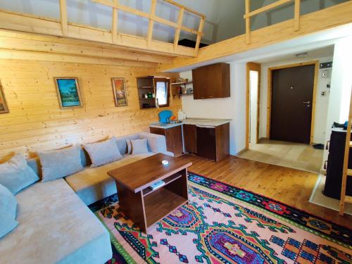 Prokosko Resort في فوينيتسا: غرفة معيشة بها أريكة وطاولة
