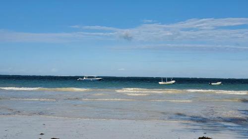 two boats in the water on a beach at 1 Bed Villa - Sleeps 2 - Wifi - Parking - Smoking in Galu
