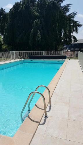 - une piscine bleue avec une chaise dans l'établissement Le grand large 