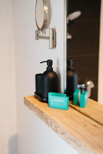 a bathroom counter with two black containers on a shelf at Chalet am Sonnenhang in Obertraun