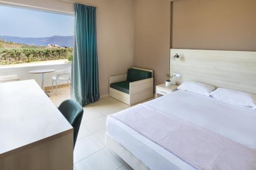 a hotel room with a bed and a large window at Elena Beach Hotel in Kissamos