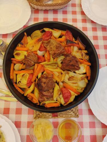 un bac rempli de viande et de légumes sur une table dans l'établissement Prokosko Resort, à Fojnica
