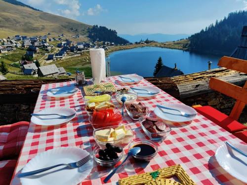 - une table de pique-nique avec de la nourriture et une vue sur le lac dans l'établissement Prokosko Resort, à Fojnica