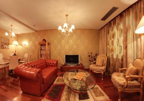 a living room with a leather couch and a television at Tirana International Hotel & Conference Center in Tirana