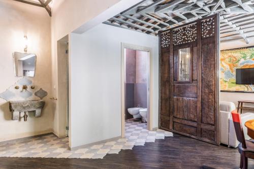 uma casa de banho com um WC e uma porta de madeira em Firenze Rentals Accademia em Florença